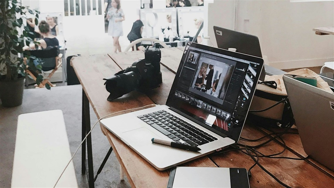 Image of a table with a laptop and camera sitting on it.